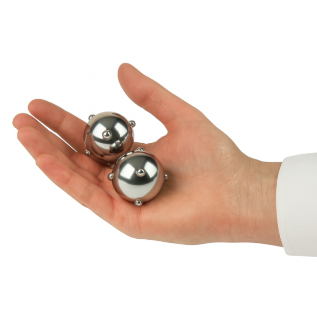 Zwei QiGong Kugeln aus Metall mit Massagenoppen auf weißem Hintergrund
