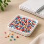 Kleine bunte Thermostar® Sensory Beads Stone aus Silikon auf einem weißen Tablett