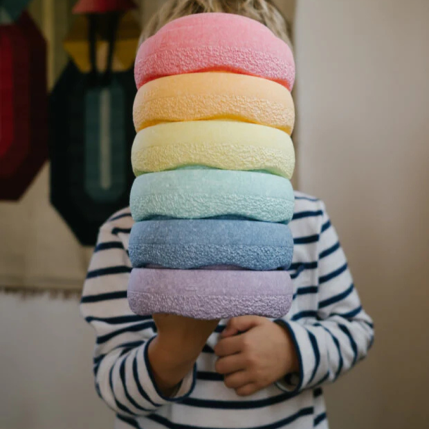 Anwendungsbild 2: Kind hält Stapelstein® Original Mini Rainbow Pastel 6 aufeinander gestapelt in der Hand.