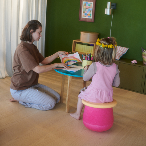 Anwendungsbild 2: Kind sitzend auf den Stapelstein® Dynamic Small flowers und am malen.
