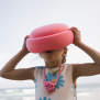 Mädchen spielt am Strand mit einem Stapelstein in Light Red – fördert Kreativität und Bewegung.