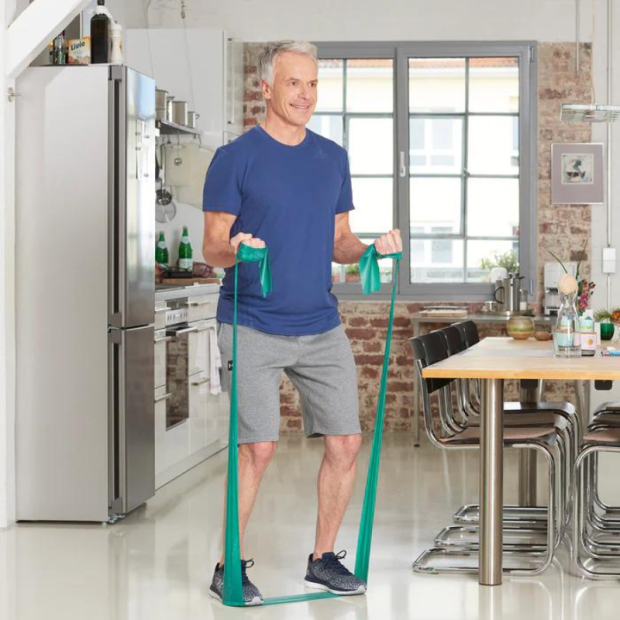 Abbildung 3: Anwendung: Frau trainiert am Boden mit rotem Band